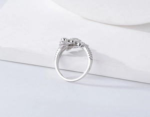 Macro shot of silver sterling ring featuring hollow floral pattern and pavé zircon stones