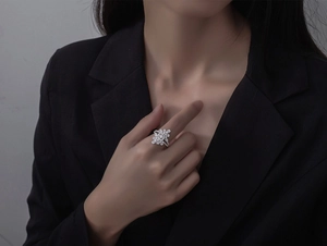Macro shot of silver micro-pave floral ring with sparkling zircon stones on black fabric