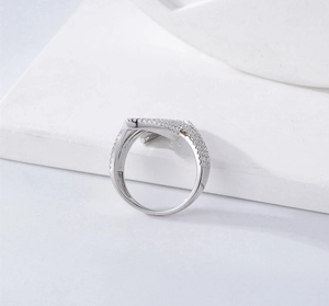 Makroaufnahme des V-förmigen S925 Silberrings mit Zirkonia-Pavé auf weißem Sockel präsentiert