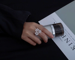 Gros plan d'une bague fleur en argent sertie de zircons portée par un mannequin