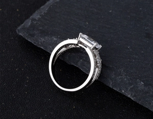Macro view of emerald-cut 925 sterling silver ring with sparkling side diamonds