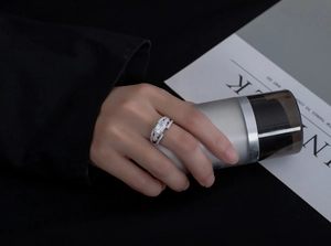 Close-up of a 925 silver emerald-cut rectangular ring with pavé side stones on hand