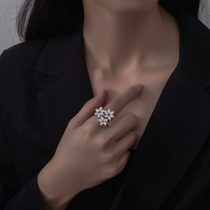 Bague fleur en argent S925 sertie de diamants pavés, portée par un mannequin sur fond noir