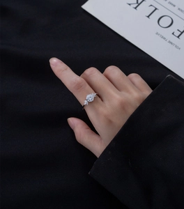 Gros plan d'une bague de fiançailles en argent 925 avec zircon rond sur le doigt d'un mannequin