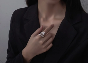 Macro detail of silver adjustable ring with pavé cubic zirconia and geometric flower motifs