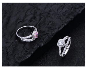 Vue détaillée des bagues en argent 925 avec cœurs rose et blanc sur roche noire