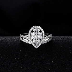 Pear-cut silver crown ring featuring micro-pave crystals on a black textured surface