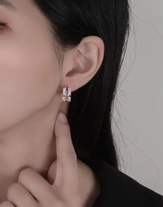 Detailed view of sterling silver drop earrings with colorful crystals on a female model