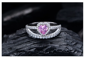 Macro d'une bague en argent 925 avec diamant rose en forme de cœur sur charbon
