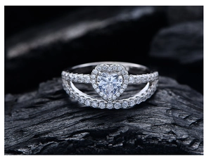 Détail macro d'une bague diamant rose en cœur avec anneau double rangée sur fond sombre
