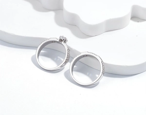 Detailed close-up of s925 silver wedding ring set with micro-pave diamonds on white stage
