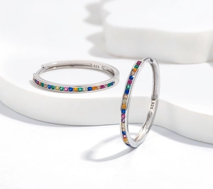 Dettaglio di orecchini a cerchio in argento 925 con zirconi colorati arcobaleno