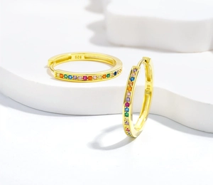 Dettaglio ravvicinato di orecchini huggie in argento S925 con pietre color arcobaleno