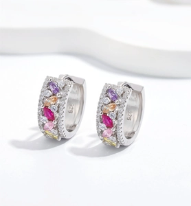 Vue macro de boucles d'oreilles huggies en argent 925 avec zircons colorés et poinçon