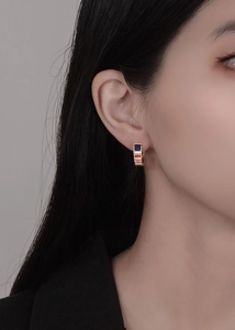 Close-up of S925 huggie earrings with colorful baguette-cut cubic zirconia in gold