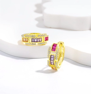 Macro shot of 925 silver gold huggie earrings with colorful stones and white pavé gems