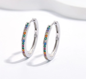 Dettaglio macro di orecchini a cerchio in argento 925 con zirconi colorati arcobaleno