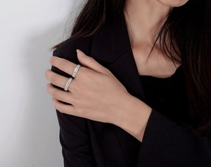 Detail of stacked S925 sterling silver rings with pave set diamonds on a model hand