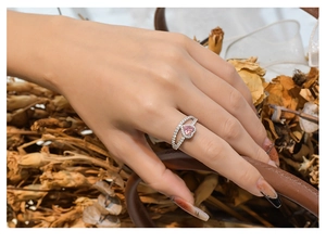 Détail d'une bague en argent 925 avec une pierre cœur rose et double anneau de zircons