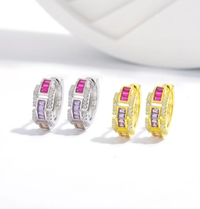 Macro shot of S925 sterling silver huggie earrings with purple zircons and 925 hallmarks