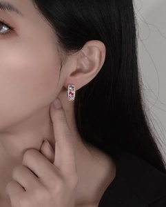 Gros plan de créoles en argent 925 avec zircons colorés sertis de pavés sur l'oreille