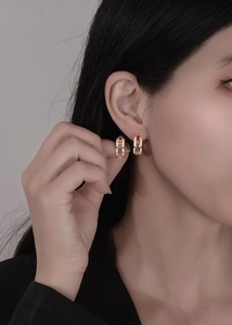 Close-up of 18k gold chain hoop earrings with multicolored square-cut gemstones