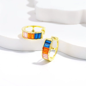 Gold hoop earrings with colorful rectangular zircons on minimalist white display