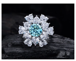 Makroaufnahme eines Blumenrings mit 8mm blaugrünem Edelstein und Herz-Blütenblättern