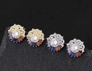 Detailed macro view of rainbow zircon flower earrings on textured stone background