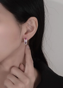 Macro detail of silver geometric link earrings with ruby and amethyst rectangle stones