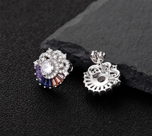 Macro detail of silver flower earrings showing colorful zircon inlay and butterfly backs