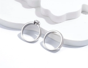 Macro shot of silver stacking ring set featuring cushion cut center and pavé bands