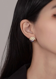 Close-up of cloud-shaped sterling silver stud earrings with colorful zircon stones on ear