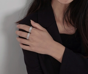 Detail of stacked S925 sterling silver rings with snowflake halo and pavé band on finger