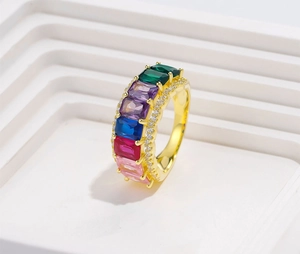 Macro view of gold-plated ring with rectangular multi-color crystals and pavé side stones