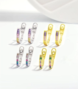 Macro detail of 925 silver hoop earrings with rainbow colored stones and gold plating