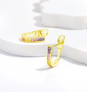 Macro detail of gold-plated 925 silver U-shape hoop earrings with colorful zircon stones