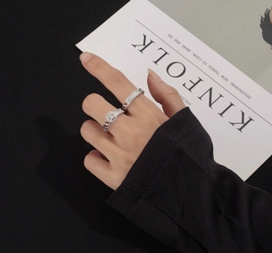 Close-up of stacked S925 silver chain rings with rectangular stone and pavé diamonds