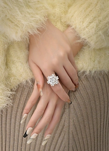 Nahaufnahme eines schneeflockenförmigen Silberrings mit Diamanten an der Hand