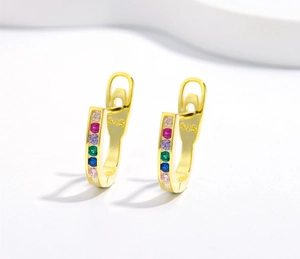 Macro detail of 925 silver U-shaped gold earrings featuring colorful pavé zircon stones