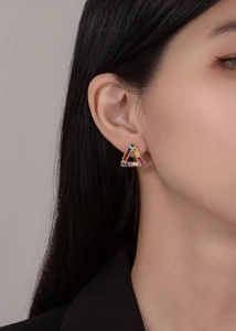 Macro shot of triangle rainbow gemstone stud earrings in 925 sterling silver on ear
