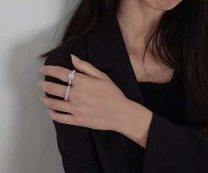 Detail of stacked S925 silver rings with emerald-cut diamond and lace pattern band