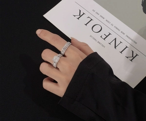 Detailed view of two stacked S925 sterling silver rings with square zircon and woven band