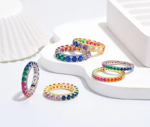 Detailed view of rainbow zircon eternity rings in gold and silver plated settings