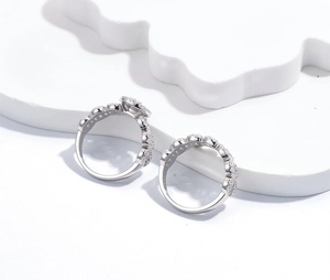 Macro shot of S925 sterling silver rings featuring pavé set diamonds and wave textures