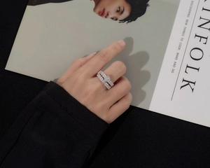 Close-up of S925 sterling silver stacked rings with cubic zirconia pavé on a model hand