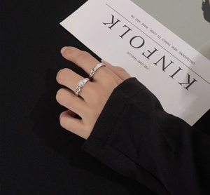 On-hand shot of S925 sterling silver ring set featuring round-cut stone and geometric band