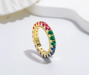 Macro view of gold rainbow eternity ring with multi-colored gemstones and milgrain edging