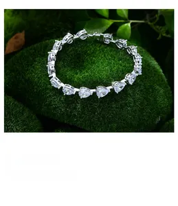 Vue macro d'un bracelet en argent 925 avec pierres poires sur fond de mousse verte