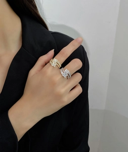 Close-up of overlapping gold and silver rings with rectangular zircon and pave diamonds